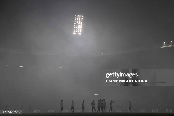 Vitoria Guimaraes players are pictures in the fog during the Portuguese League football match between Vitoria Guimaraes SC and FC Porto at the Dom...