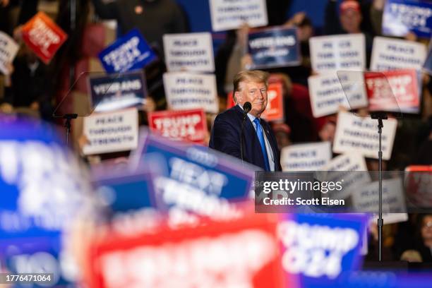 Supporter of Republican presidential candidate former President Donald Trump hold up signs while he delivers remarks during a campaign event on...