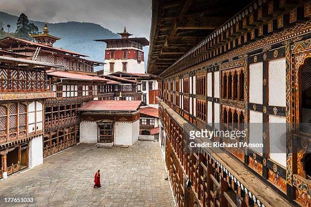 monk in courtyard at trongsa dzong - bhoutan photos et images de collection