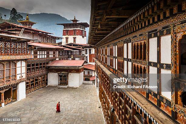 monk in courtyard at trongsa dzong - bhutan stock pictures, royalty-free photos & images