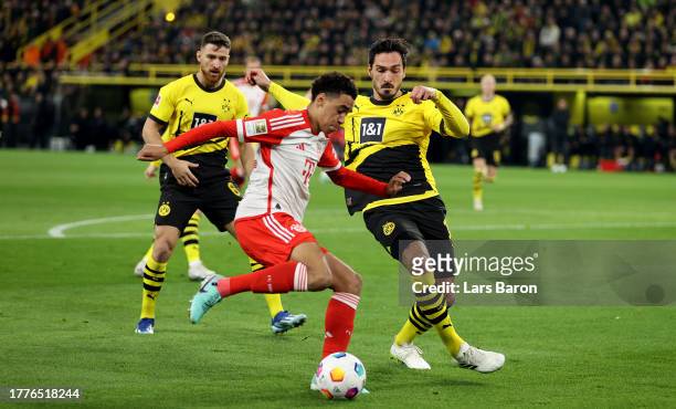 Jamal Musiala of Bayern Munich is challenged by Mats Hummels of Borussia Dortmund during the Bundesliga match between Borussia Dortmund and FC Bayern...