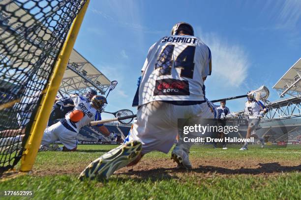 John Grant Jr. #24 of the Chesapeake Bayhawks gets a shot past Adam Ghitelman and Brett Schmidt of the Charlotte Hounds during the MLL Championship...