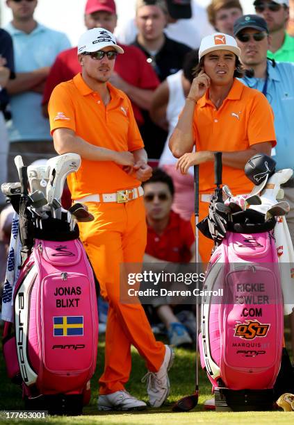 Rickie Fowler of the United States and Jonas Blixt of Sweden stand on the 13th tee during the final round of The Barclays at Liberty National Golf...