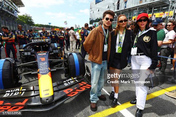Sasha Meneghel and Bruna Marquezine pose for a photo with the car of Max Verstappen of the Netherlands and Oracle Red Bull Racing on the grid prior...