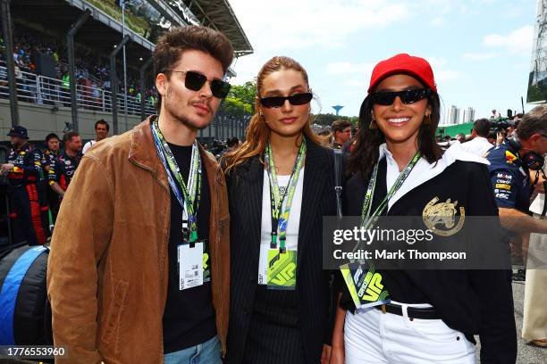 Sasha Meneghel and Bruna Marquezine pose for a photo with the car of Max Verstappen of the Netherlands and Oracle Red Bull Racing on the grid prior...