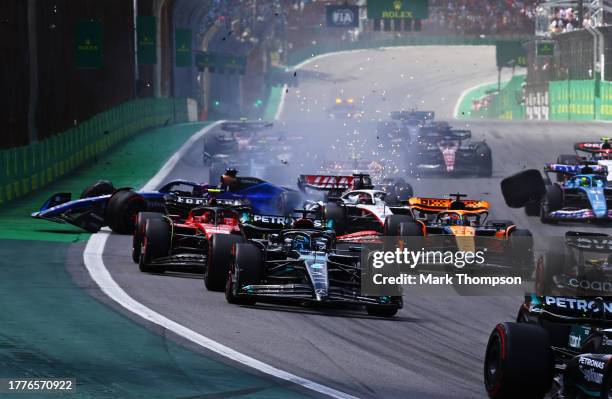 Alexander Albon of Thailand driving the Williams FW45 Mercedes and Kevin Magnussen of Denmark driving the Haas F1 VF-23 Ferrari crash into turn one...