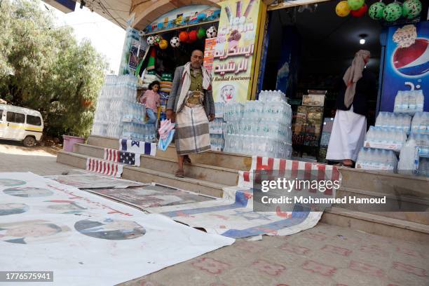 Yemeni man walk on a banner painted with pictures of Israeli PM Netanyahu, Presidents of the U.S., UAE, Egypt, Syria, the King of Jordan, the...