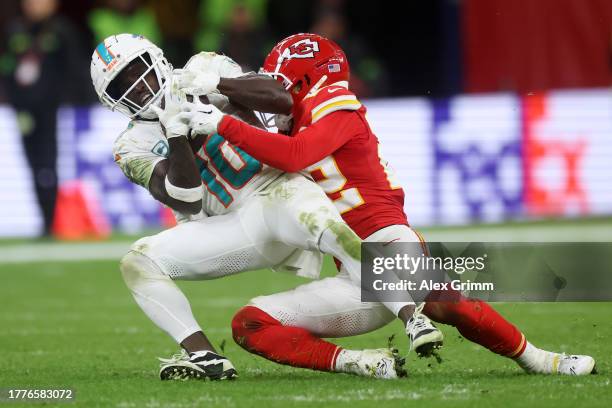 Tyreek Hill of the Miami Dolphins is tackled by Trent McDuffie of the Kansas City Chiefs in the fourth quarter during the NFL match between Miami...