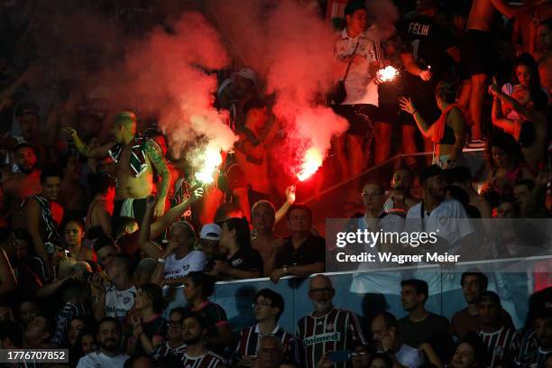 Fluminense fans cheer with flares during the match between Flamengo and Fluminense as part of Brasileirao 2023 at Maracana Stadium on November 11,...