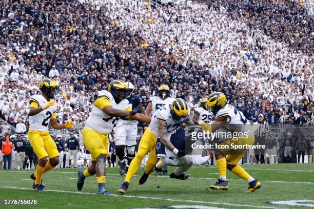 Group of Michigan Wolverines defenders tackle Penn State Nittany Lions quarterback Drew Allar during a college football game on November 11, 2023 at...