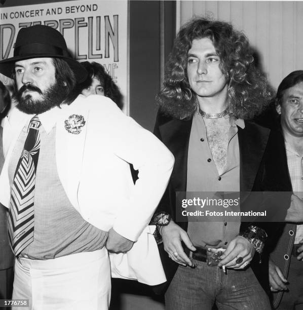British singer Robert Plant , lead singer of the rock band Led Zeppelin, holds a lit cigarette while standing with John Bonham, the band's drummer,...