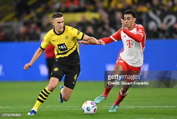 Jamal Musiala of Bayern is challenged by Nico Schlotterbeckof Dortmund during the Bundesliga match between Borussia Dortmund and FC Bayern München at...