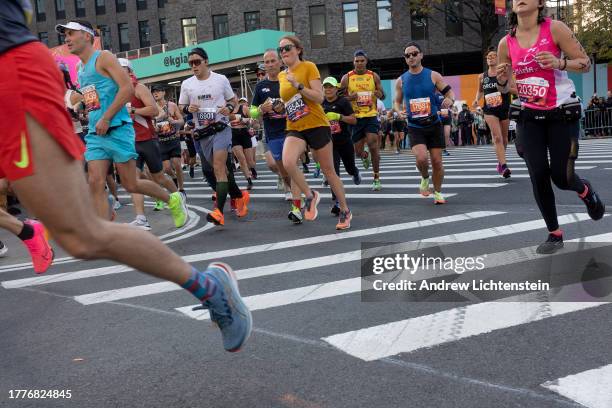 Marathon runners, cheered on by crowds of pedestrians, participate in the annual New York City Marathon on November 5 through the streets of...