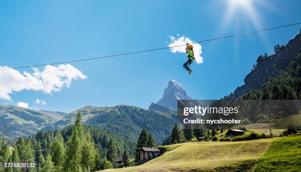 viaje a suiza - chica joven en tirolina en zermatt con matterhorn en el fondo - alpes europeos fotografías e imágenes de stock