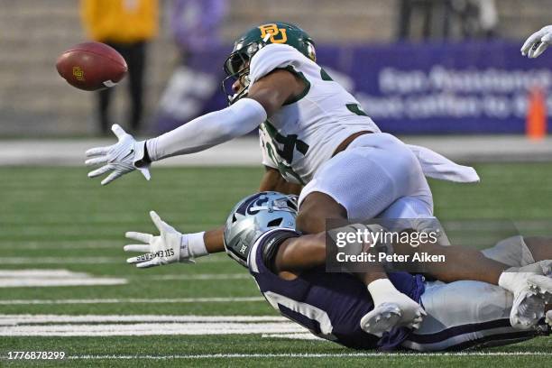 Wide receiver Josh Cameron of the Baylor Bears fumbles the ball after getting hit by safety Colby McCalister of the Kansas State Wildcats in the...
