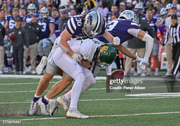 Punter Palmer Williams of the Baylor Bears fumbles the ball after getting hit by safety Matthew Maschmeier of the Kansas State Wildcats in the first...
