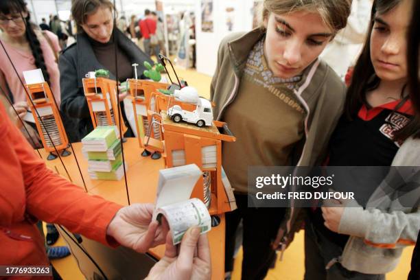 Deux jeunes filles regardent des petits livres animés, le 28 octobre 2005, sur un des stands du 25e Festival de la bande dessinée "Quai des bulles"...