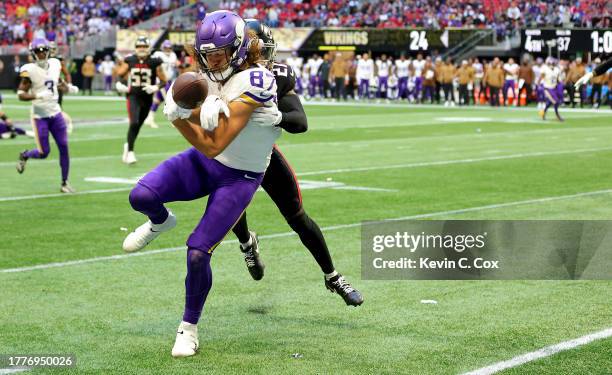 Mike Hughes of the Atlanta Falcons tackles T.J. Hockenson of the Minnesota Vikings during the fourth quarter of the game at Mercedes-Benz Stadium on...