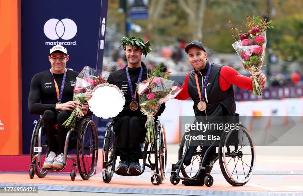 Silver medalist Daniel Romanchuk of the United States, gold medalist Marcel Hug of Switzerland and bronze medalist Jetze Plat of the Netherlands pose...