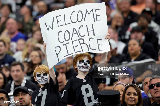 Las Vegas Raiders fans Alexandros Kheel and his brother Ezra Kheel of Nevada hold up a sign welcoming interim head coach Antonio Pierce of the...