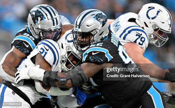 Amare Barno and Derrick Brown of the Carolina Panthers tackle Zack Moss of the Indianapolis Colts during the second quarter of the game at Bank of...
