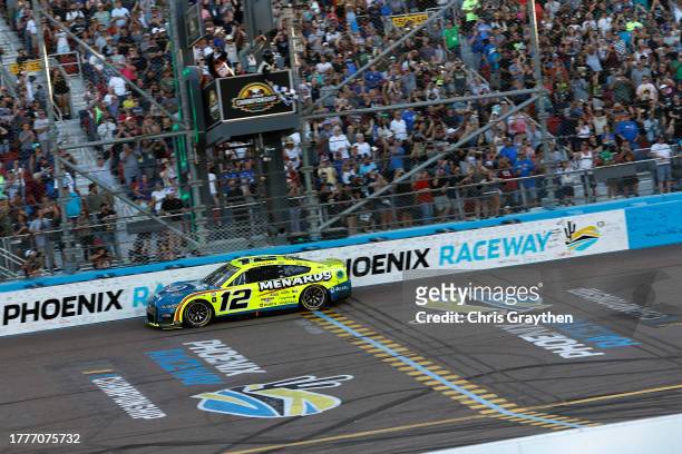 Ryan Blaney, driver of the Menards/Dutch Boy Ford, crosses the finish line to win the 2023 NASCAR Cup Series Championship, finishing first of the...