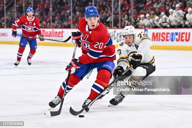 Juraj Slafkovsky of the Montreal Canadiens skates the puck against Charlie McAvoy of the Boston Bruins during the second period at the Bell Centre on...