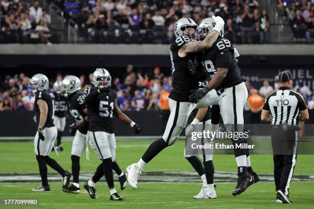Maxx Crosby and Adam Butler of the Las Vegas Raiders celebrate after a sack in the third quarter of a game against the New York Giants at Allegiant...