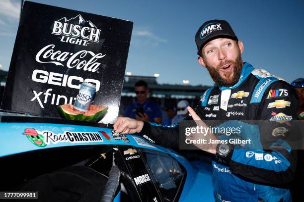 Ross Chastain, driver of the Worldwide Express Chevrolet, places the winner sticker on his car in victory lane after winning the NASCAR Cup Series...