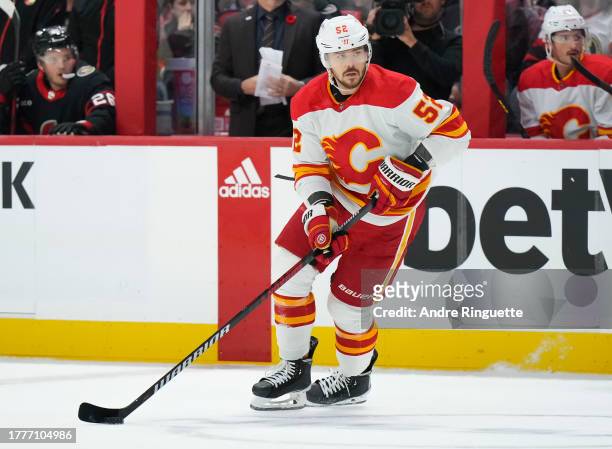 MacKenzie Weegar of the Calgary Flames controls the puck against the Ottawa Senators at Canadian Tire Centre on November 11, 2023 in Ottawa, Ontario,...