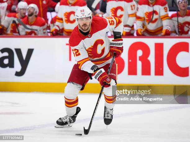 MacKenzie Weegar of the Calgary Flames controls the puck against the Ottawa Senators at Canadian Tire Centre on November 11, 2023 in Ottawa, Ontario,...