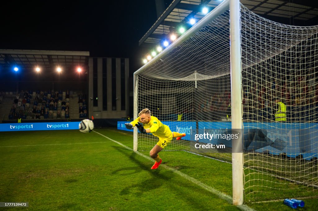 Goleiro de futebol pegando bola