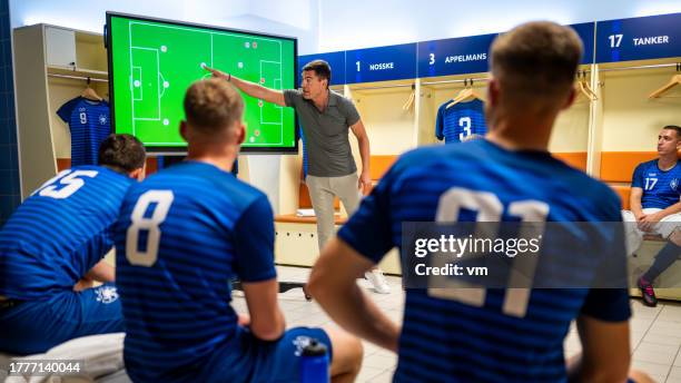soccer coach showing players positioning on screen - coach locker room stock pictures, royalty-free photos & images