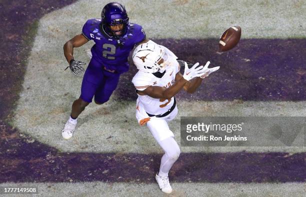 Adonai Mitchell of the Texas Longhorns catches a touchdown pass as Josh Newton of the TCU Horned Frogs defends during the first half at Amon G....