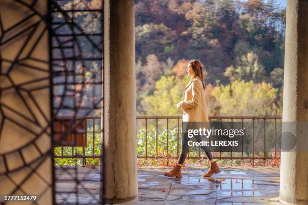 elegant female tourist on a walk in a european city - lerexis stockfoto's en -beelden