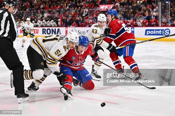 Matthew Poitras of the Boston Bruins and Jake Evans of the Montreal Canadiens battle for the puck during the third period at the Bell Centre on...