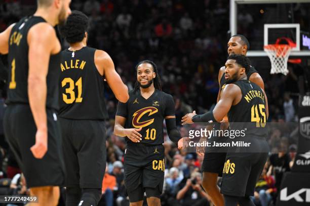 Darius Garland celebrates with Jarrett Allen and Donovan Mitchell of the Cleveland Cavaliers after Garland scored at Rocket Mortgage Fieldhouse on...