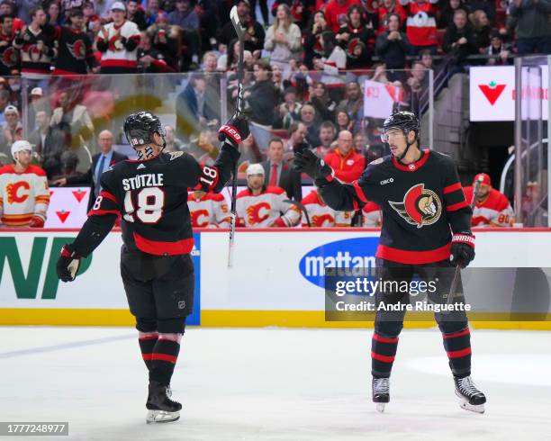 Travis Hamonic of the Ottawa Senators celebrates his third period goal against the Calgary Flames with teammate Tim Stützle at Canadian Tire Centre...