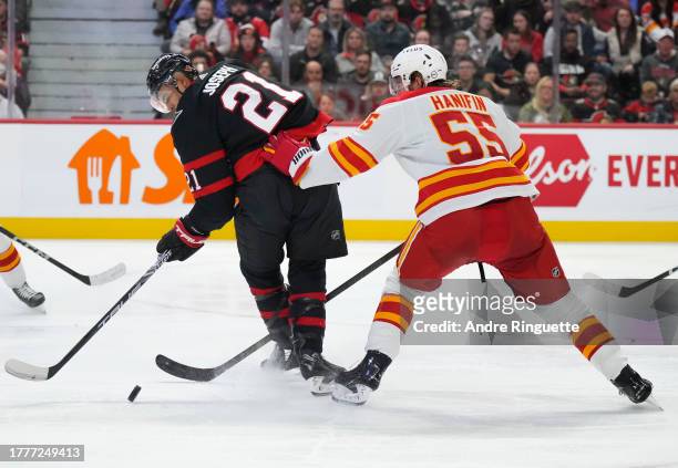 Mathieu Joseph of the Ottawa Senators controls the puck against Noah Hanifin of the Calgary Flames at Canadian Tire Centre on November 11, 2023 in...