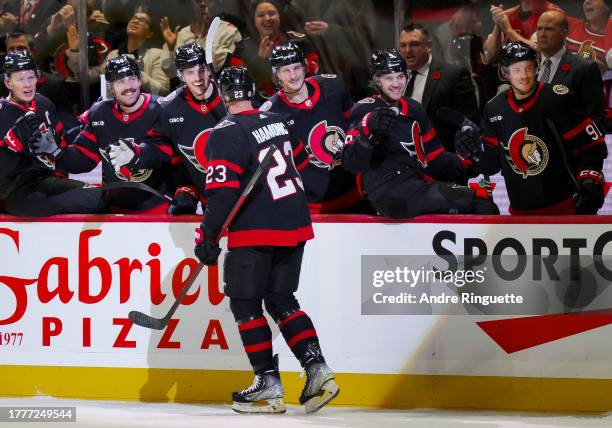 Travis Hamonic of the Ottawa Senators celebrates his third period goal against the Calgary Flames with teammates at the players' bench at Canadian...