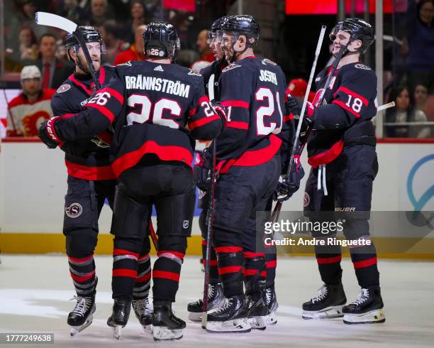Travis Hamonic of the Ottawa Senators celebrates his third period goal against the Calgary Flames with teammates Tim Stützle, Erik Brannstrom,...