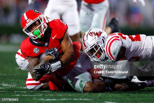 Kendall Milton of the Georgia Bulldogs is tackled by Trey Washington of the Mississippi Rebels during the first half at Sanford Stadium on November...