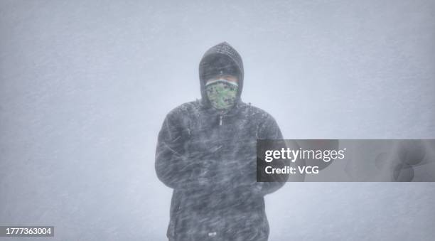 Citizen walks along a road during a snowstorm on November 6, 2023 in Harbin, Heilongjiang Province of China.