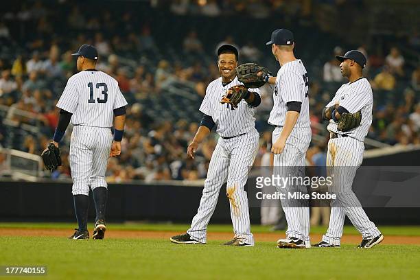 Alex Rodriguez of the New York Yankees walks away as Robinson Cano, Lyle Overbay and Eduardo Nunez laugh during the game against the Los Angeles...