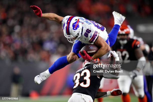 Dalton Kincaid of the Buffalo Bills leaps over Nick Scott of the Cincinnati Bengals before fumbling the ball during the third quarter at Paycor...