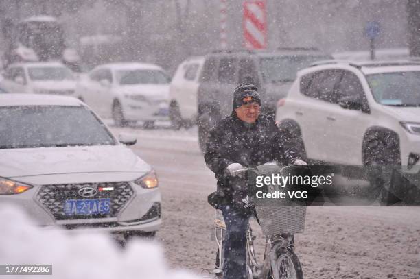 Citizen rides an electric bike during a snowstorm on November 6, 2023 in Harbin, Heilongjiang Province of China.