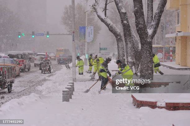 Workers clean up snow on a street during a snowstorm on November 6, 2023 in Harbin, Heilongjiang Province of China.