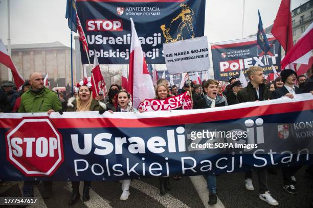People are seen holding anti-U.S. And anti-Israeli banners during the Independence March in Warsaw. Poland's National Independence Day marks the...