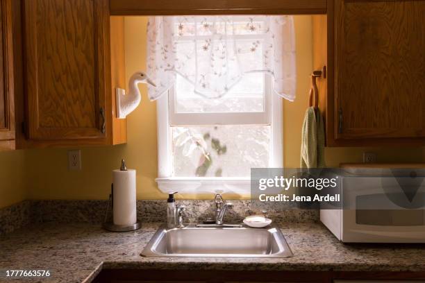 cute kitchen window, clean kitchen sink inside domestic home interior, happy morning light - trapo de fregar fotografías e imágenes de stock
