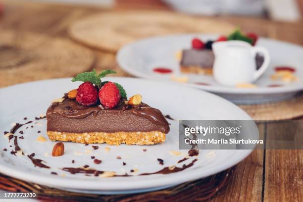 dairy free raw vegan chocolate cake with berries and seeds. healthy dessert for gluten free dieting. - cashew pieces stock pictures, royalty-free photos & images